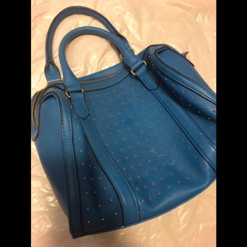 Gently used bright blue handbag. Gold studded accent on one side.
